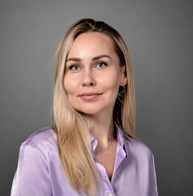 Наталья Корсакова. Я молодая женщина со светлыми длинными волосами, в лавандовой атласной блузке и серебряных украшениях. У меня округлые черты лица, высокие скулы, лёгкая спокойная улыбка.